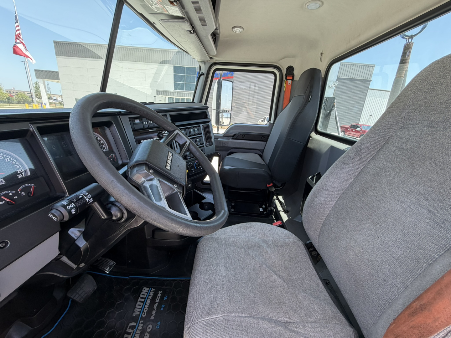 Cab interior of a 2020 Mack PI64T conventional daycab showing steering wheel, dashboard, and two front seats.