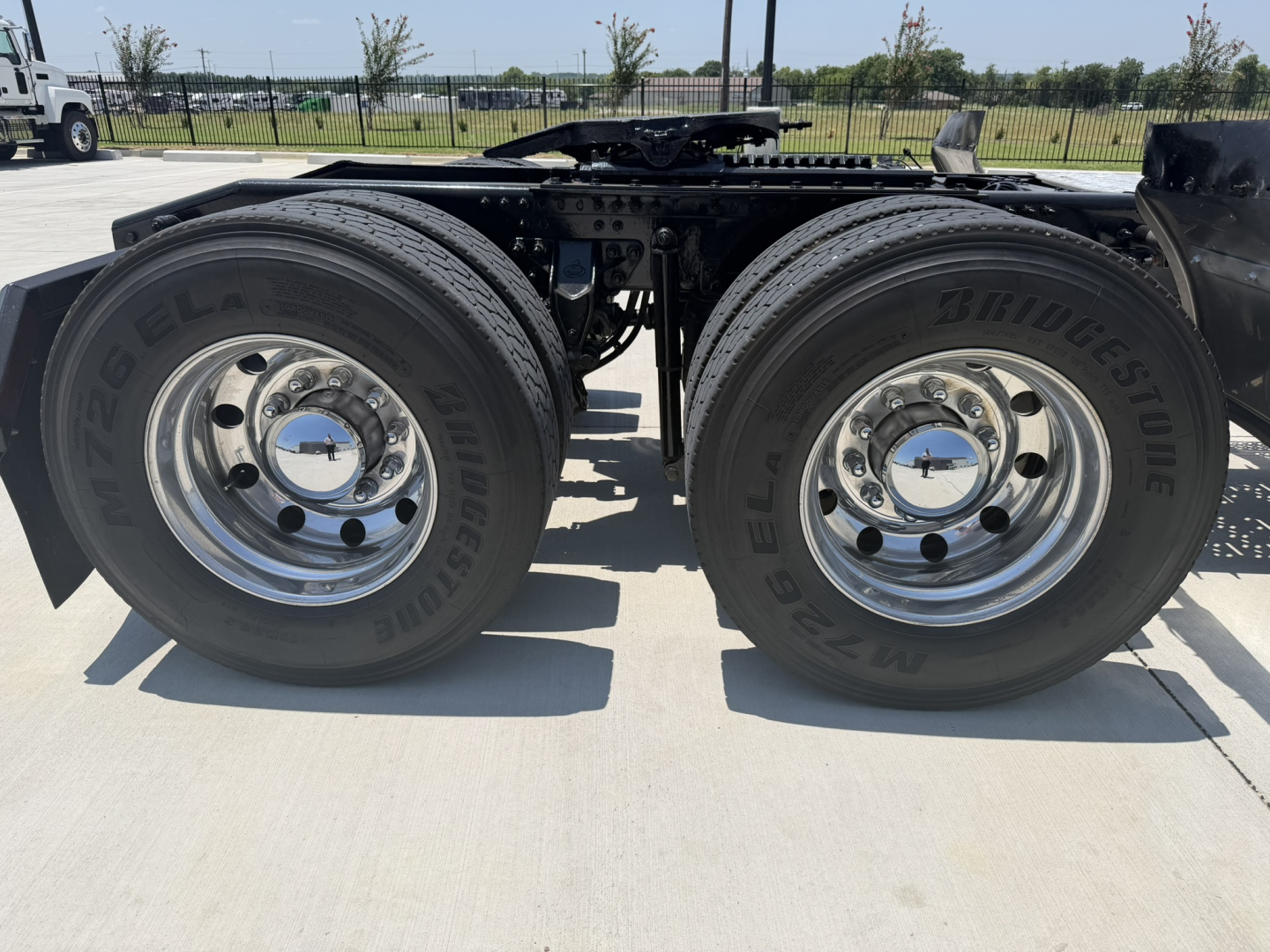 Dual rear wheels of a 2020 Mack PI64T truck showing tires and chrome wheels with hubcaps.