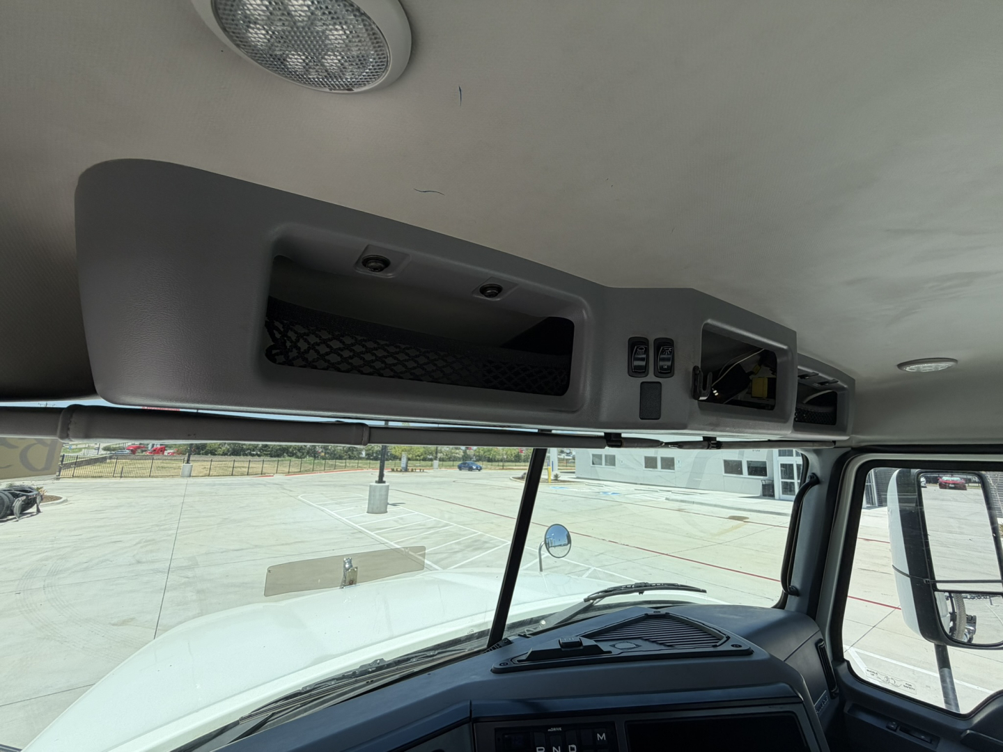 Interior ceiling console and dashboard of a 2020 Mack PI64T daycab showing overhead storage compartments and control panel.