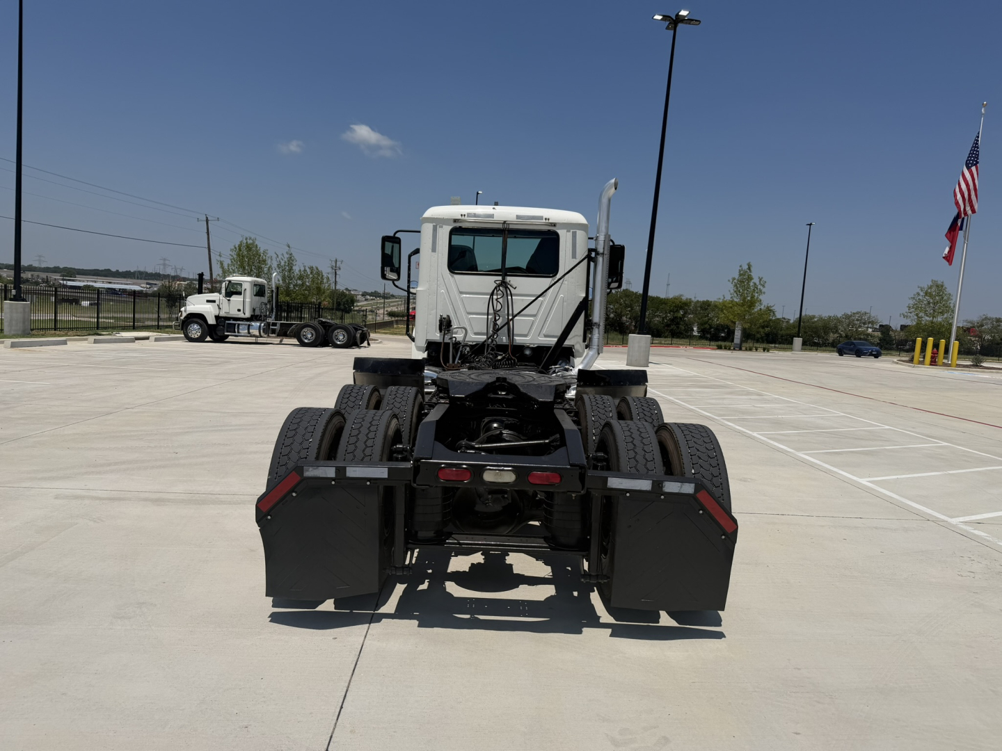 Truck chassis rear view of a 2020 Mack PI64T conventional daycab showing dual rear axles and fifth-wheel area.