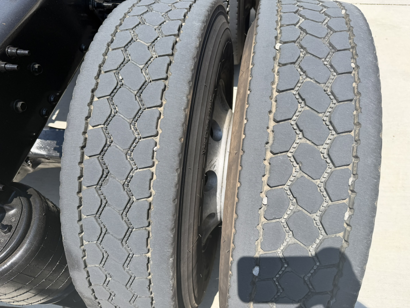 Dual rear tires of a Mack PI64T truck showing tread pattern and wheel rims.