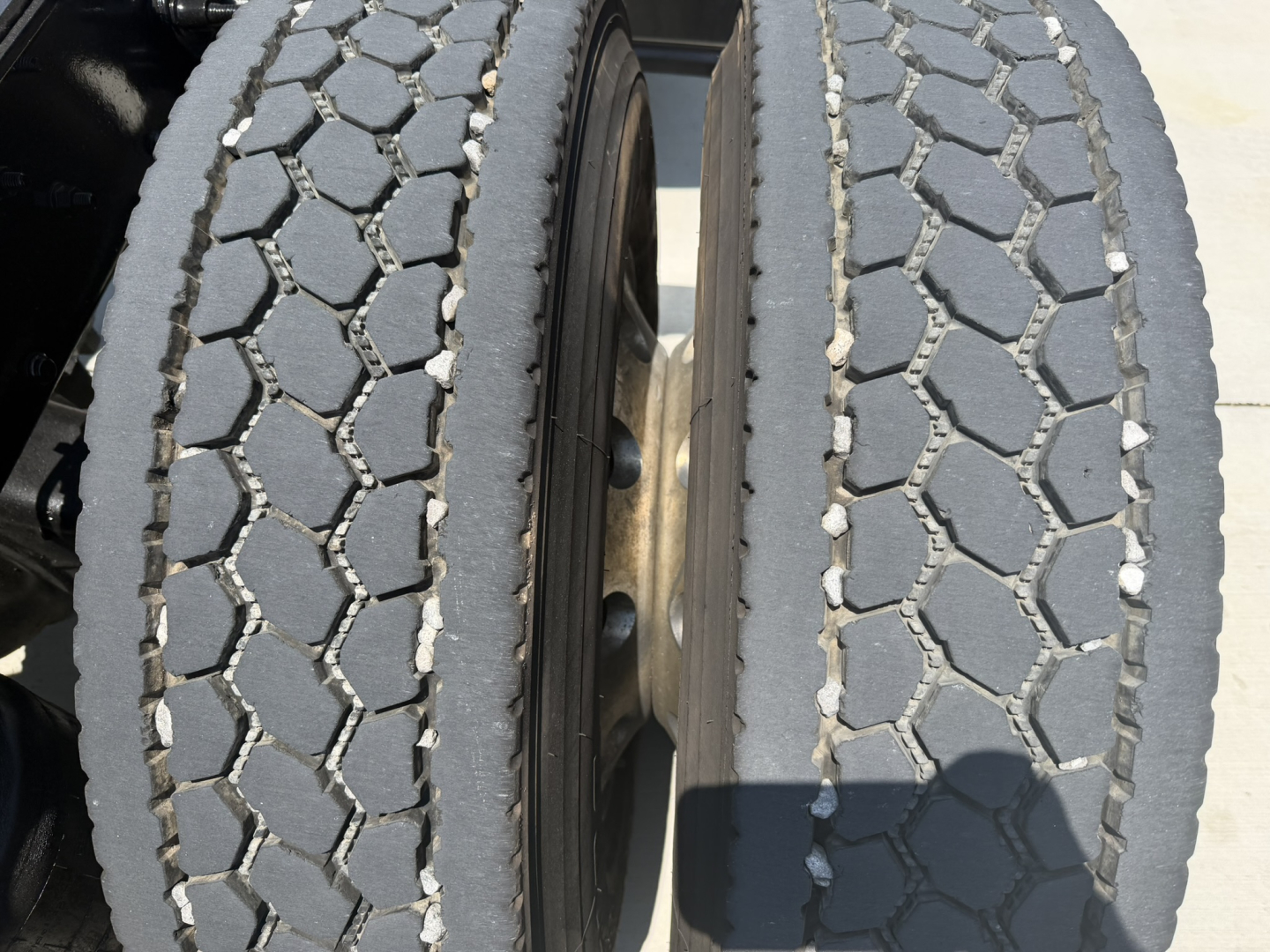 Left and right front dual tires of a 2020 Mack PI64T daycab truck showing tread pattern and wheel hubs.