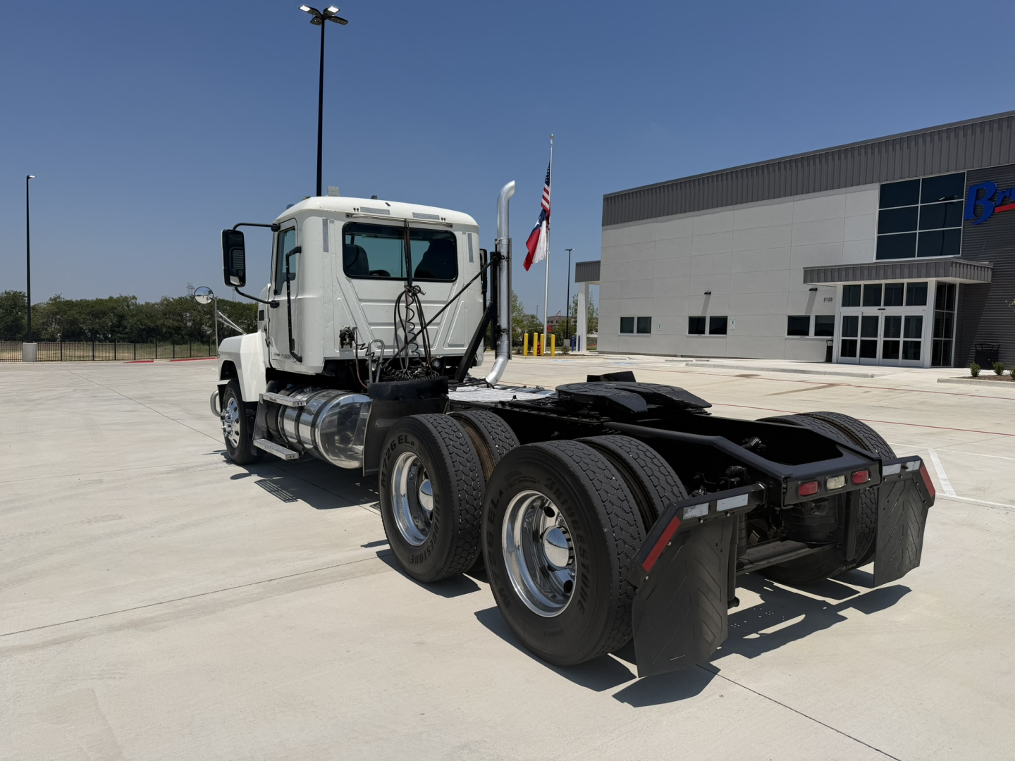 Truck tractor back and driver cab of a 2020 Mack PI64T daycab viewed from rear-left side.