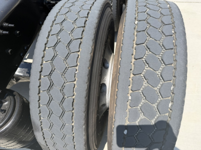 Dual rear tires of a Mack PI64T truck showing tread pattern and wheel rims.