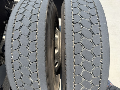 Truck axle showing dual rear tires with distinctive hexagonal tread pattern on the PI64T Mack truck.