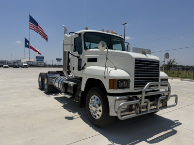 Mack PI64T truck in a parking lot showing front grille, bumper guard, chrome wheels, and dual rear axles.