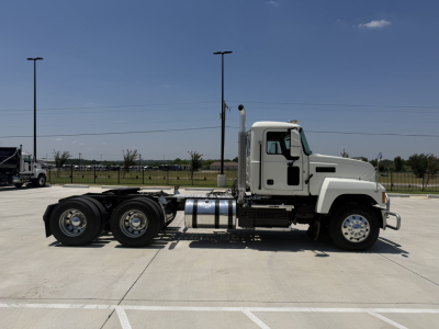 Truck side view showing 2020 Mack PI64T conventional daycab with 6x4 tandem rear axles, cab, fuel tanks, and exhaust stack.