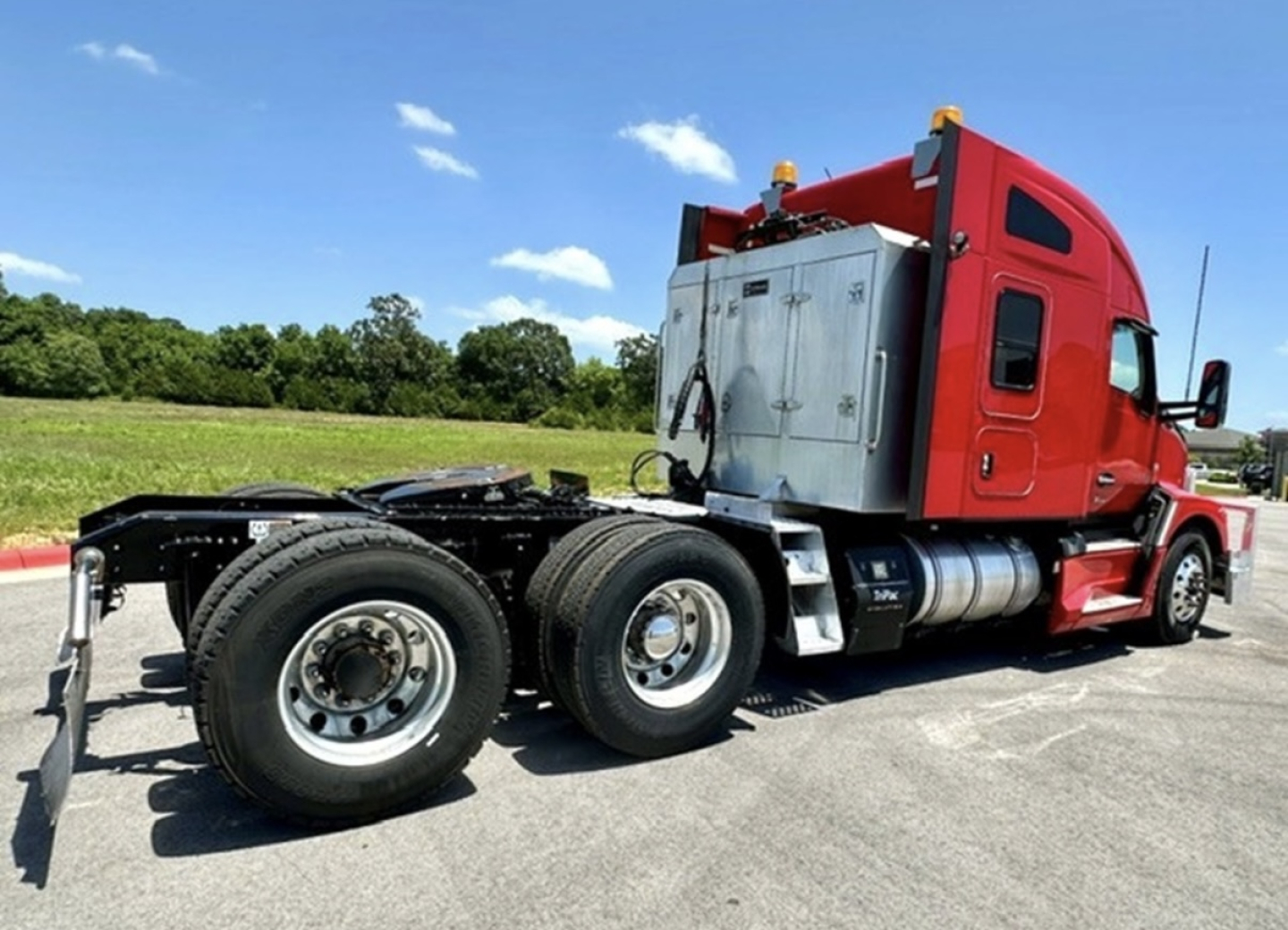 Kenworth T680 tractor rear view showing chassis, dual rear axles, and red sleeper cab with silver battery/technical box.