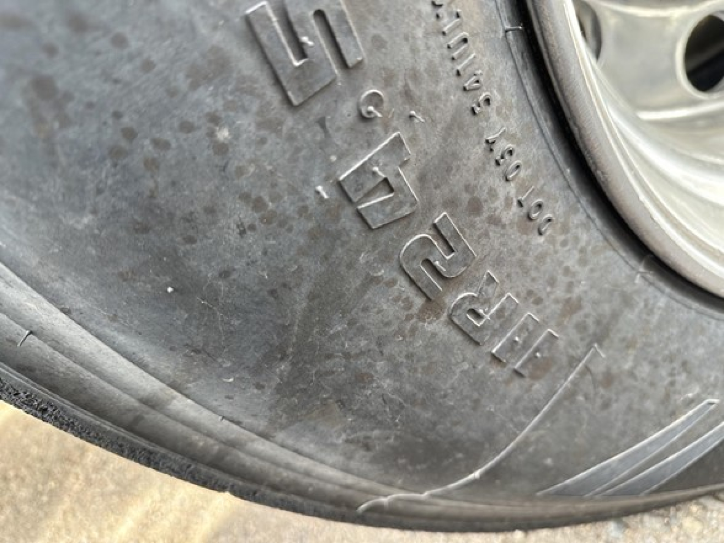 Tire sidewall with raised lettering on a dump trailer wheel showing Goodyear or similar tire brand and tread detail.