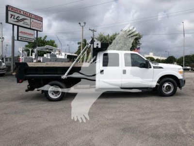 Ford F-350 dumped truck in white with dump bed and hydraulic hoist visible, side view.