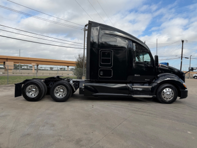 Kenworth T680 conventional sleeper truck side view showing black cab and rear chassis with dual rear axles.