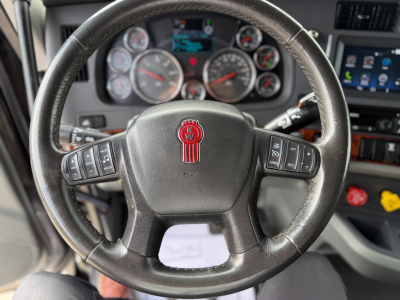 Kenworth T680 steering wheel and instrument cluster inside cab showing round gauges and center display.