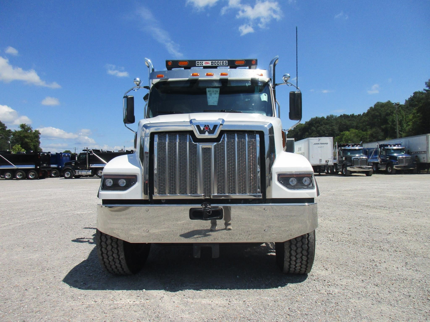 Front view of a white Western Star 49X dump truck showing grille, bumper, and headlights.