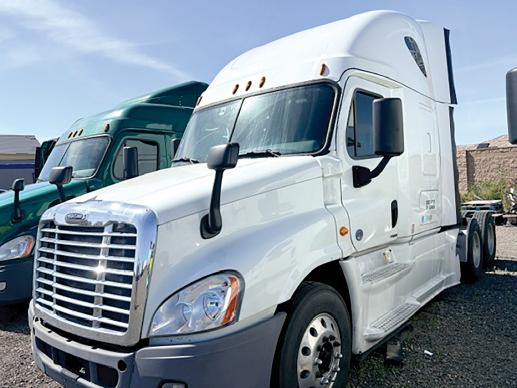 Truck cab in white showing Freightliner Cascadia125 sleeper tractor with chrome grille and aerodynamic mirrors, front view.
