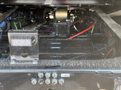 Trailer hitch area showing electrical wiring and a small rectangular indicator on a black metal frame.