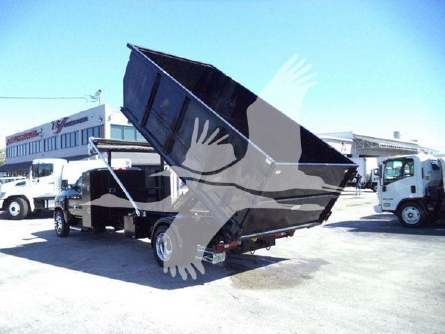 Truck bed dump truck shown with raised dump body on a Chevrolet Silverado 6500 chassis, side view highlighting roll-off/dump configuration.