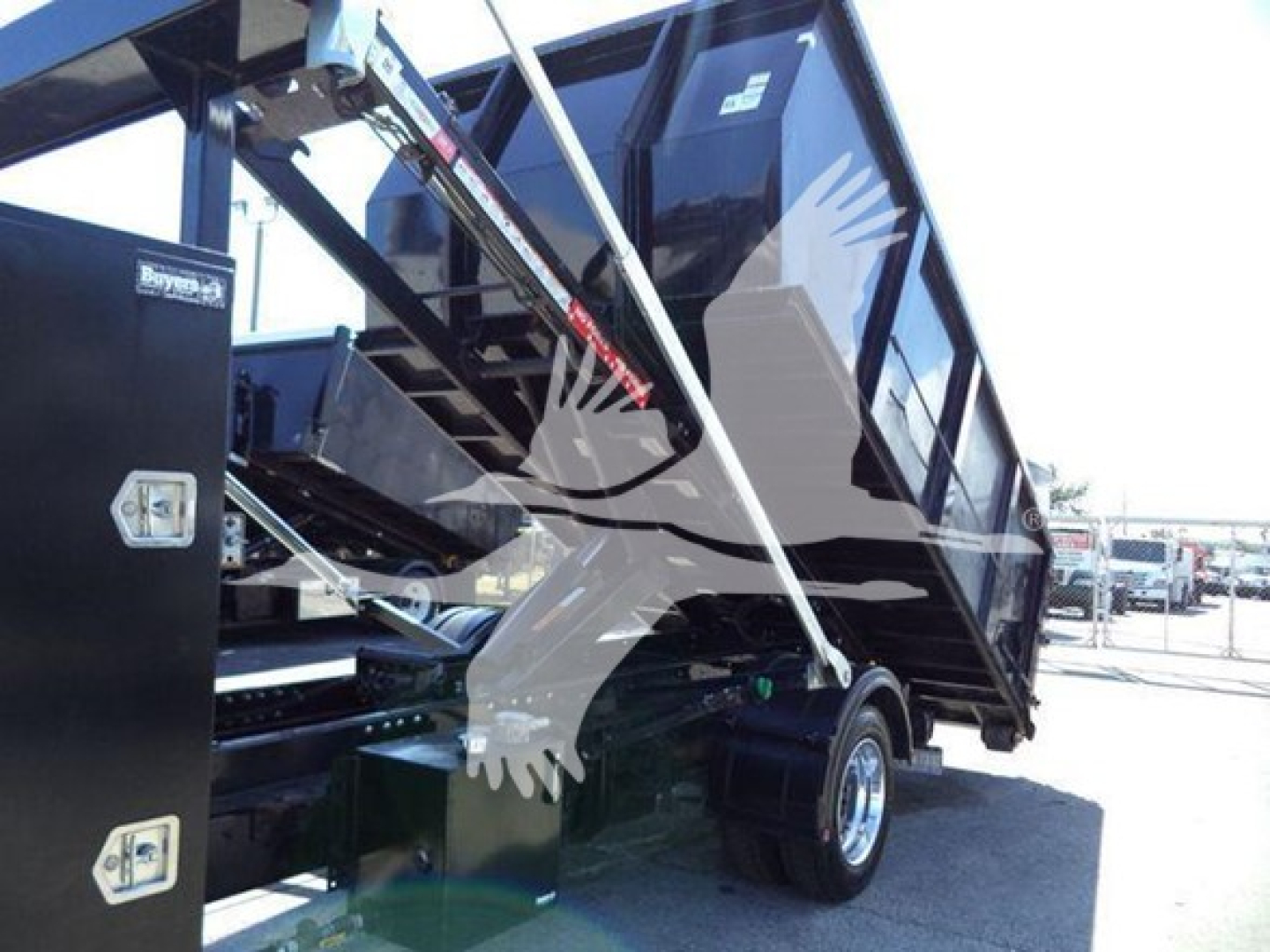 Truck bed hoist system on a 2023 Chevrolet Silverado 6500HD with a tilted dump bed and hydraulic mechanism.
