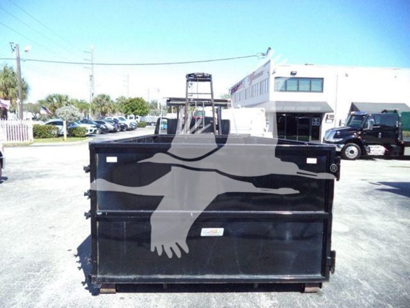 Dump truck bed showing cargo area with black metal sides and a graphic bear graphic on the side.