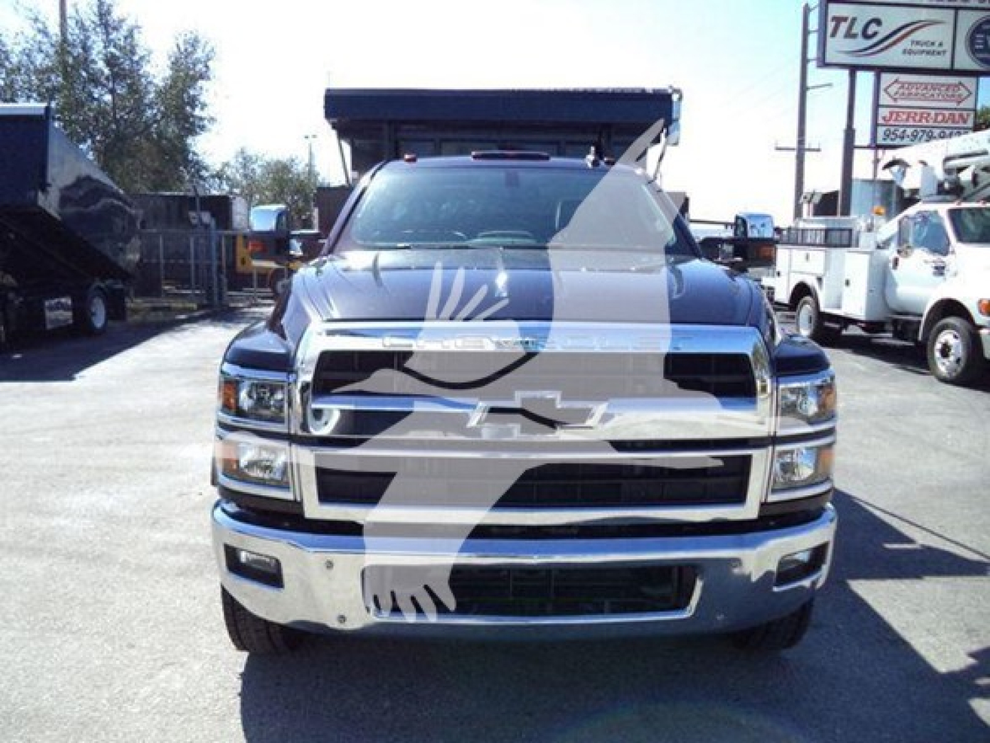 Chevrolet Silverado 6500HD front view showing chrome grille and bumper, Dually/HD style truck in a dealership lot.