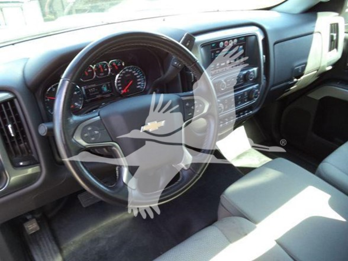 Interior dashboard and steering wheel of a Chevrolet Silverado 6500HD crew cab with gray seats and center console visible.