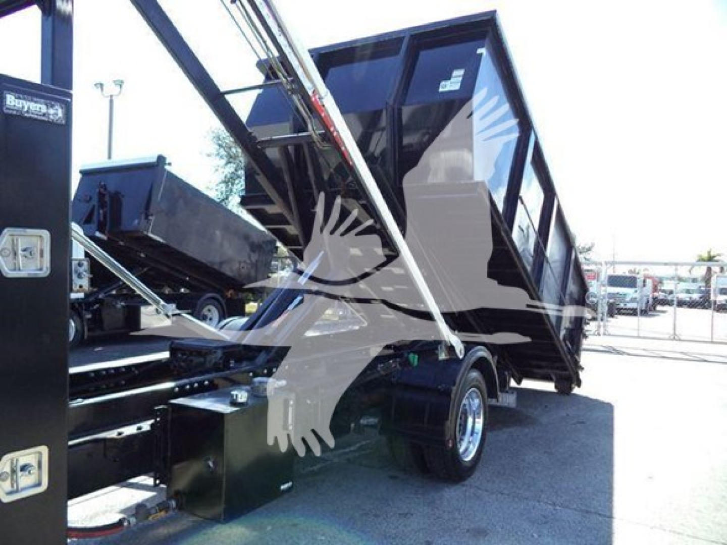 Truck bed hoist system on a Silverado 6500hd with hydraulic arms and a tilted dump bed