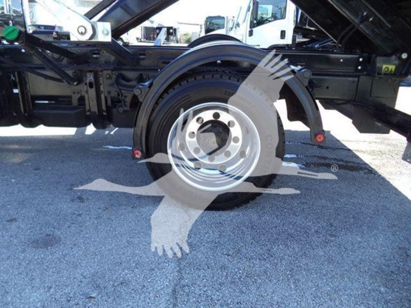 Military gray wheel and tire assembly of a heavy-duty Chevrolet Silverado 6500HD chassis showing spare wheel and surrounding frame components.