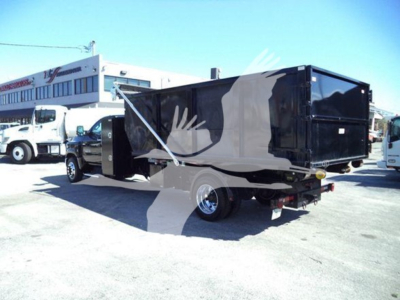 Truck bed of a 2023 Chevrolet Silverado 6500HD rolloff truck showing black dump body and rear hitch.