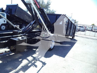 Chevrolet Silverado 6500HD roll-off truck bed with hydraulic arms and dump container, side view showing black chassis and wheels.