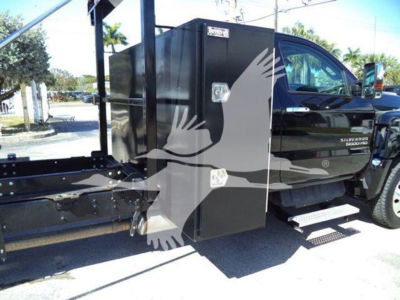 Truck cab side showing storage box mounted near the door and steps, Silverado 6500HD badge visible.