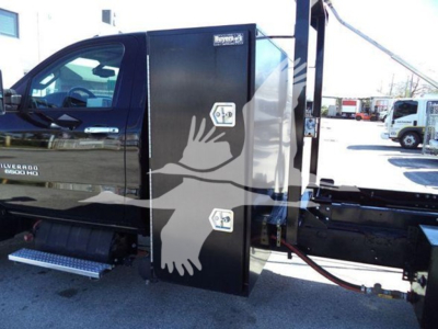 Truck side view showing a black utility toolbox mounted on a Silverado 6500HD chassis with dual doors and side steps visible.
