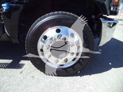 Truck wheel and tire with chrome hubcap on Silverado 6500HD wheel well view.