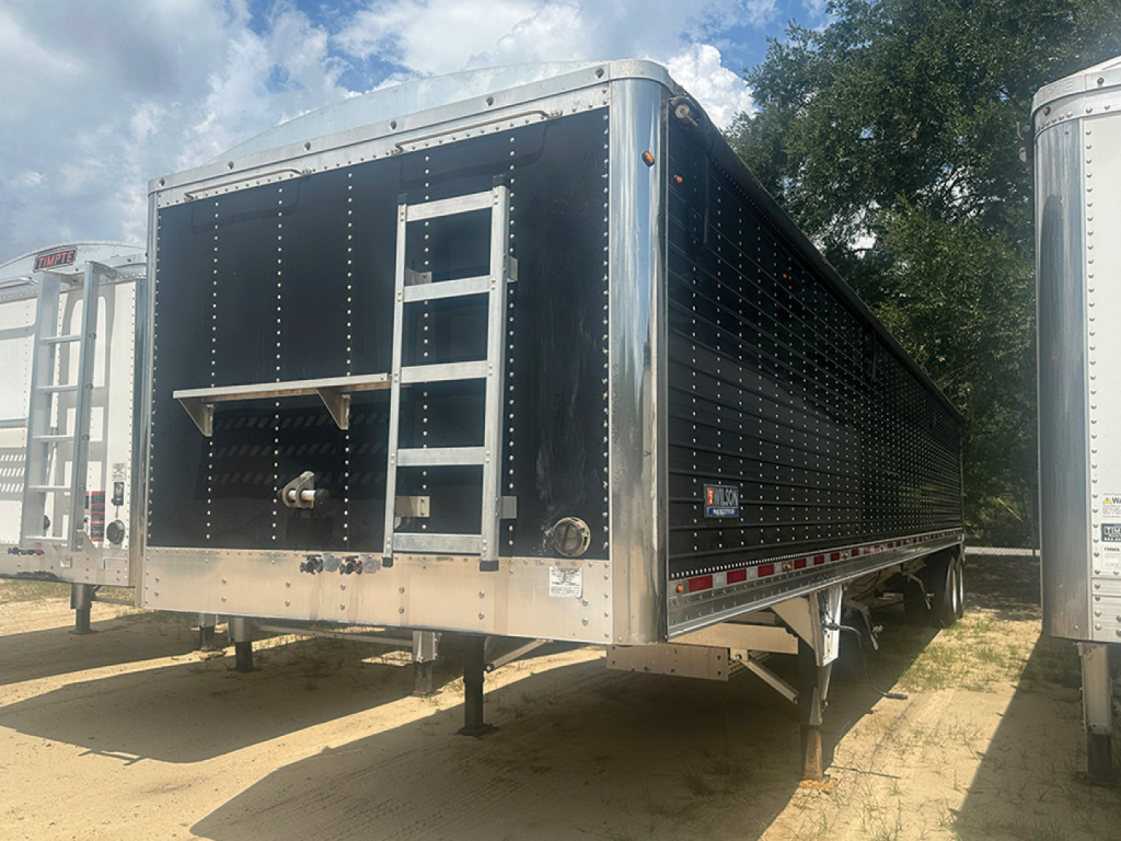 Trailer side and rear of a black Wilson Pacesetter hopper trailer with ladder and tool rack visible.