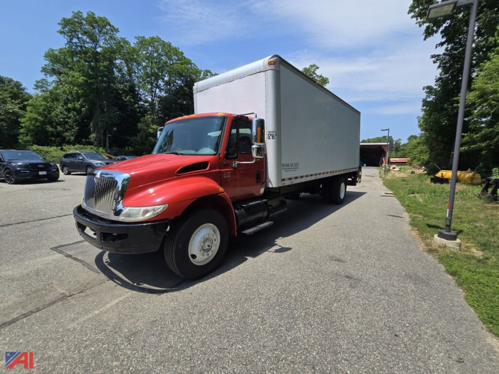 Box truck showing 2008 International 4400 with red cab and large white box in a parking lot.