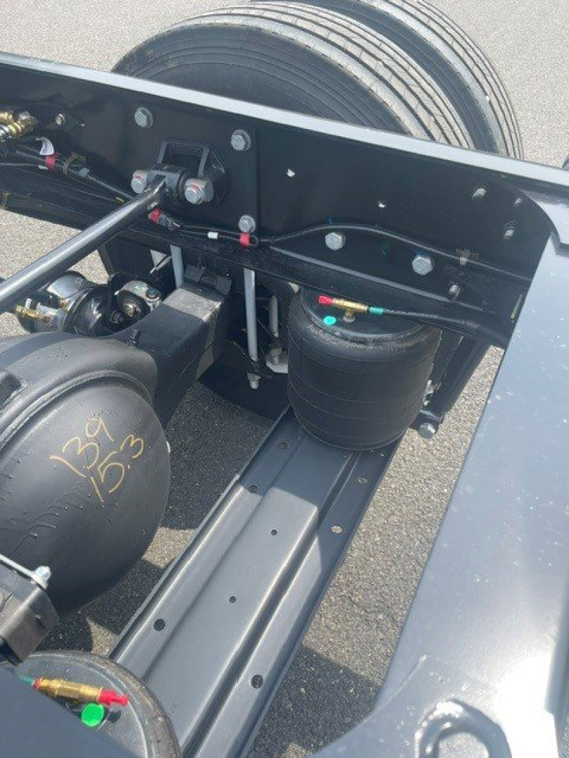 Truck chassis showing air reservoirs and hydraulic lines with visible labels; handwritten markings on an air tank reading '134 135' and various hoses and fittings.