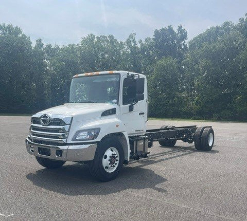 White 2027 Hino L6 cab chassis truck in a parking lot showing front of cab and chassis bed.