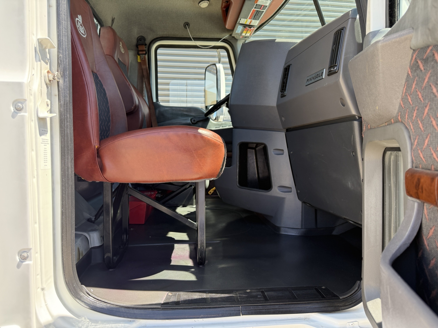 Mack CXU612 truck cab interior showing front seats and dashboard with steering area visible.