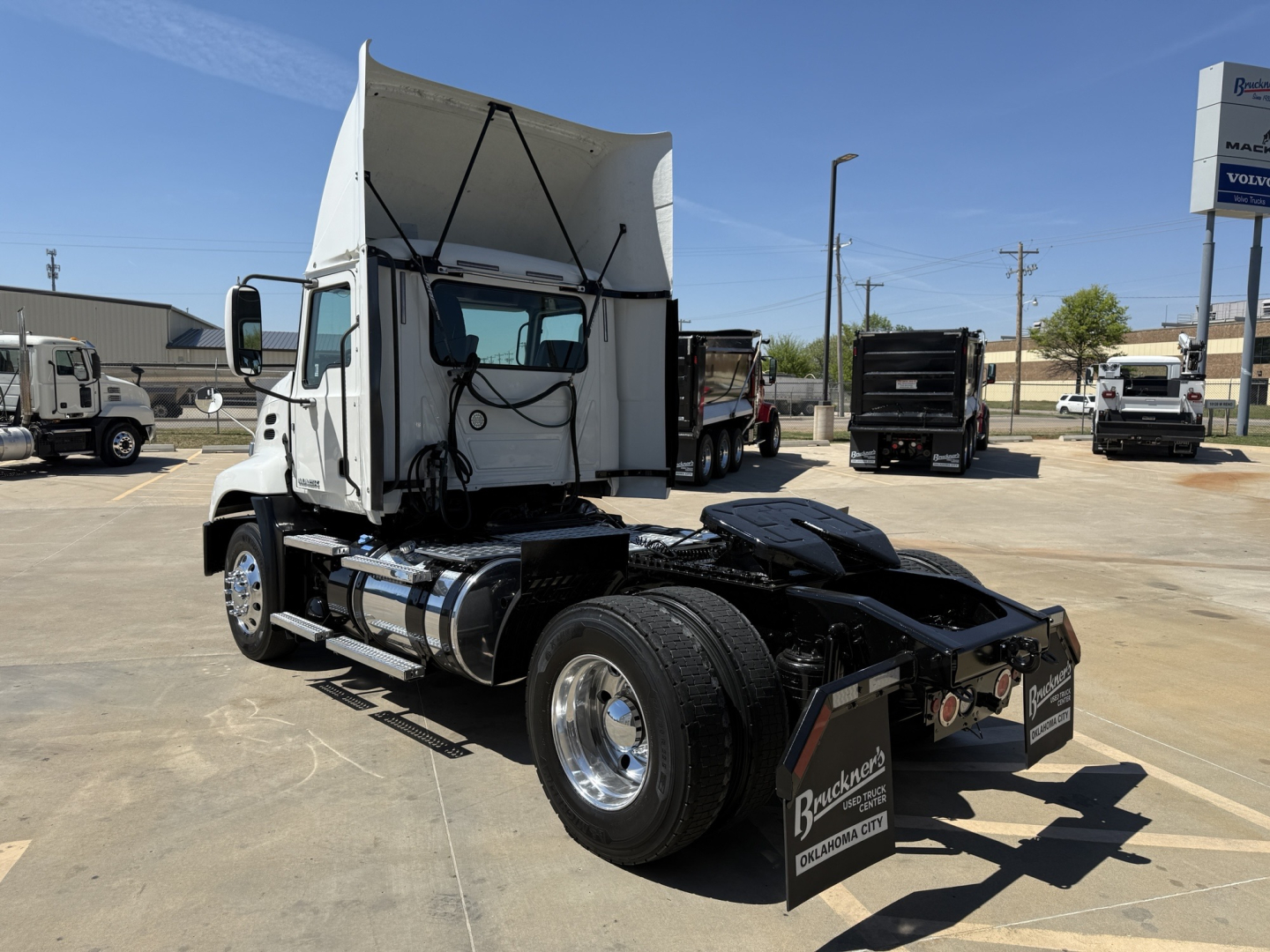 2018 Mack CXU612 daycab truck chassis with raised sleeper compartment and exposed fuel tanks, side view showing dual rear wheels, hitch, and rear mud flaps.
