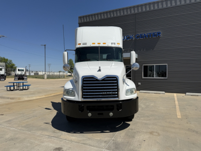 Conventional daycab truck front view of a white 2018 Mack CXU612 with large grille, bumper, and cab mirrors in a parking lot.