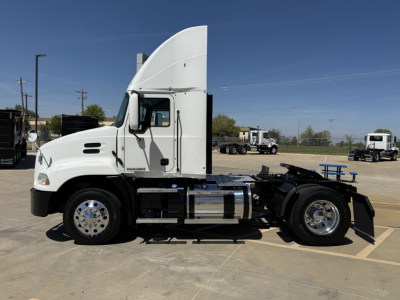 Side profile of a white 2018 Mack CXU612 daycab truck showing cab, fuel tanks, and wheel rims.