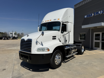 White 2018 Mack CXU612 conventional daycab truck in showroom lot showing front and driver side.