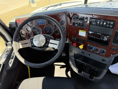 Mack CXU612 interior showing steering wheel, dashboard gauges, and control panel with woodgrain trim.