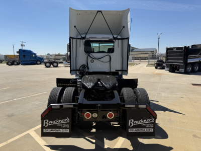 Rear view of 2018 Mack CXU612 daycab tractor showing dual rear axles, mud flaps with Bruckner's Used Truck Center Oklahoma City logos, and fifth wheel area.