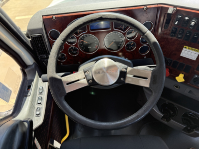 Mack CXU612 truck cockpit with steering wheel, dashboard gauges, and control panels visible.