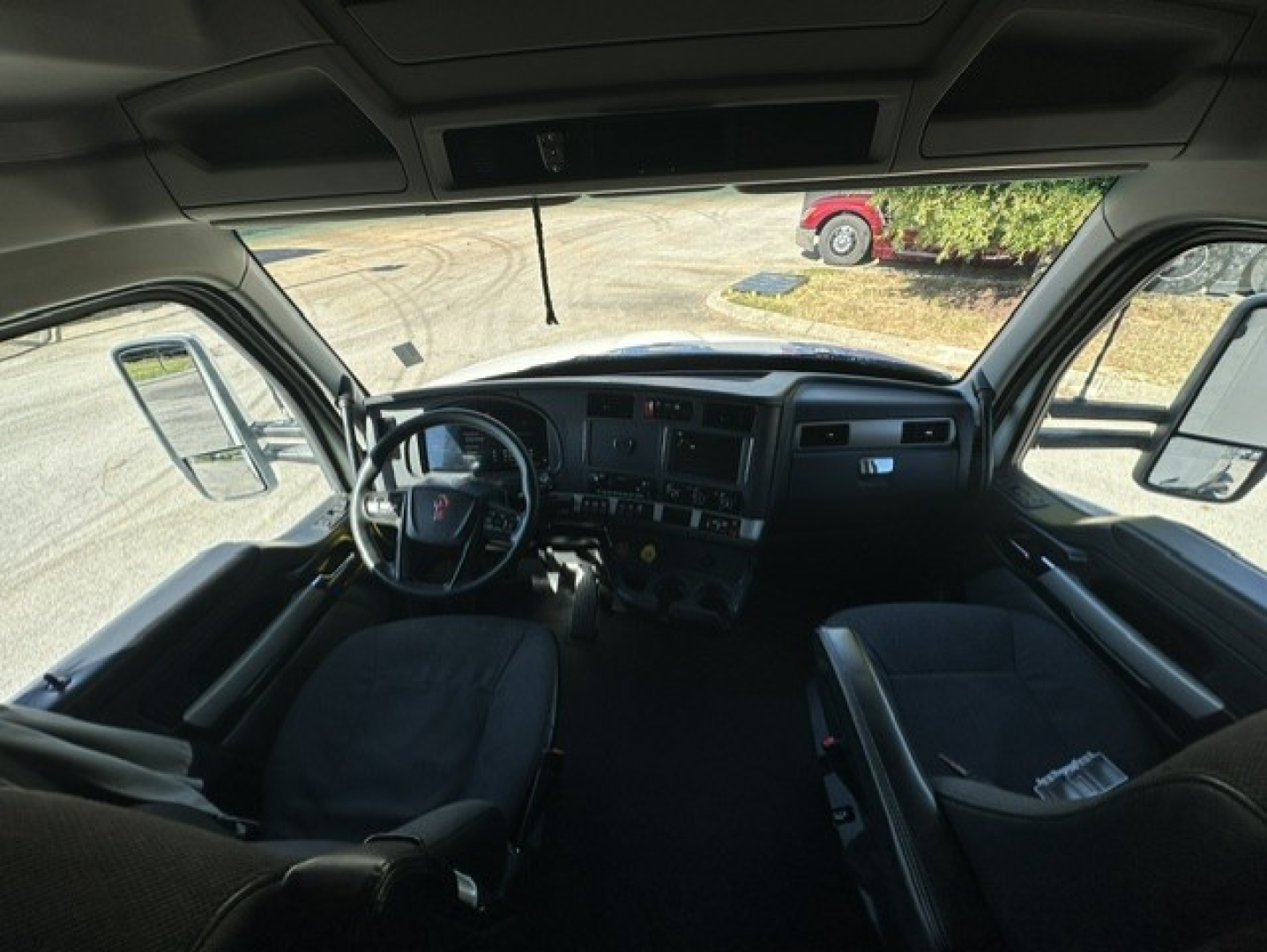 Kenworth T680 truck cab interior view showing dashboard, steering wheel, and seats.