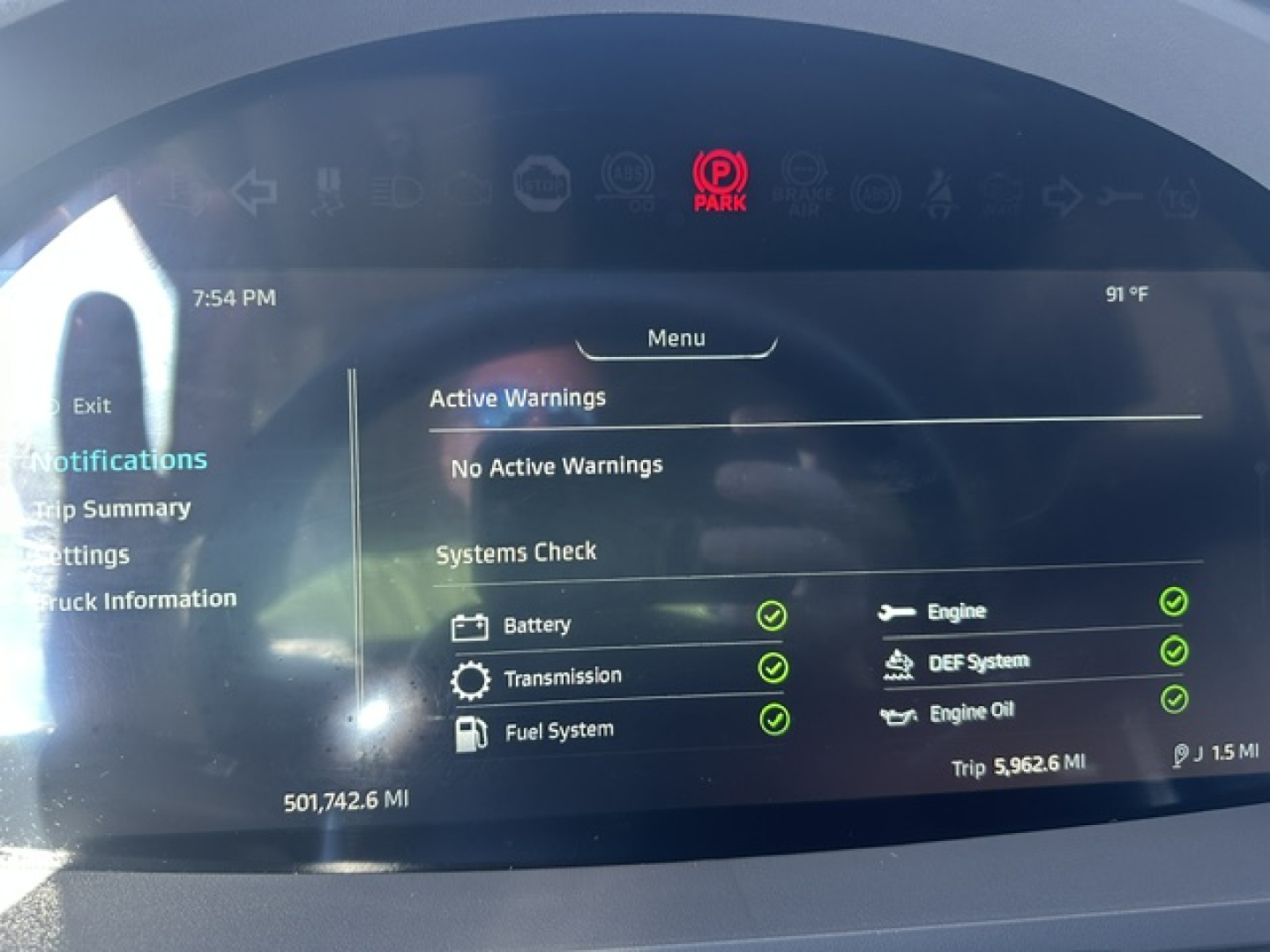 Infotainment screen in a 2022 Kenworth T680 showing active warnings and a systems check with green check marks.