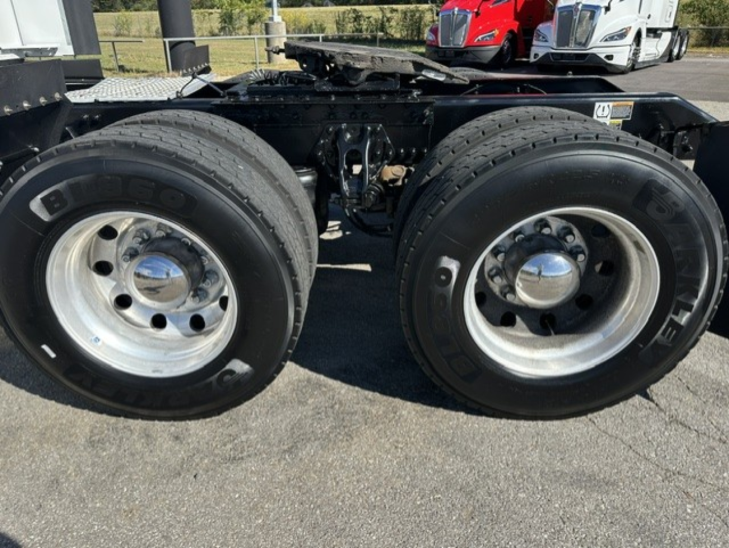 Kenworth T680 truck rear dual wheels and chassis framing with chrome hubcaps.