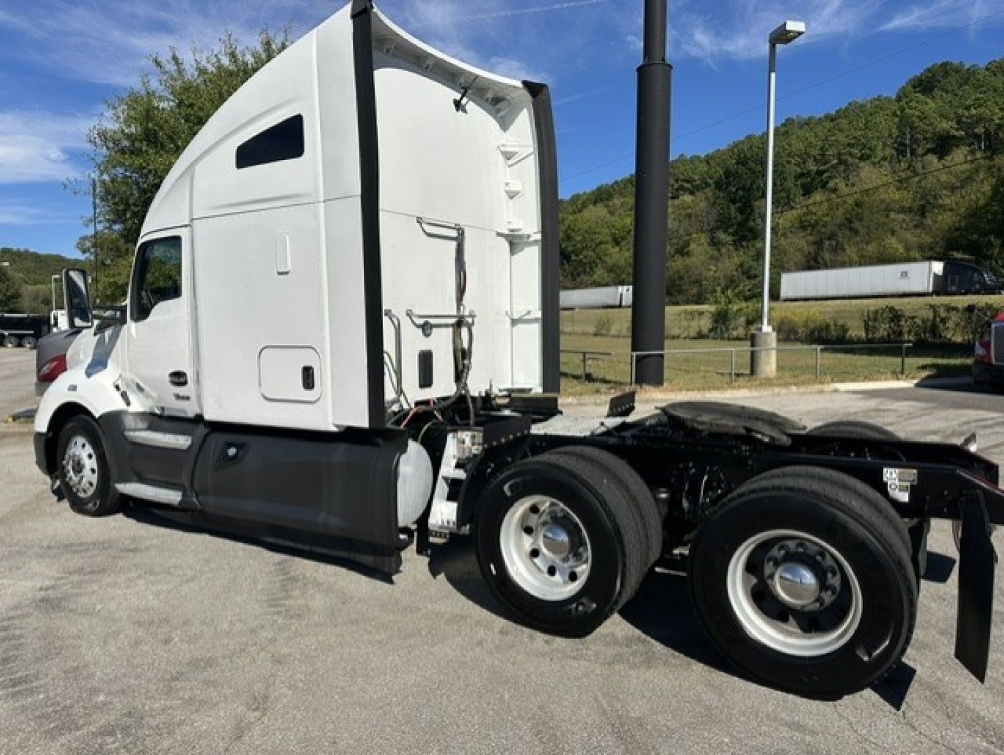 Kenworth T680 sleeper cab truck side view showing 6x4 chassis and rear wheels.