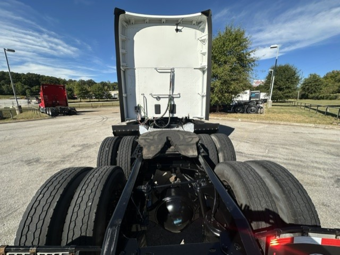 Tractor-trailer rear view showing fifth wheel and dual rear axles under a Kenworth T680 cab.