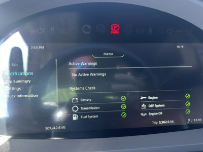 Infotainment screen in a 2022 Kenworth T680 showing active warnings and a systems check with green check marks.