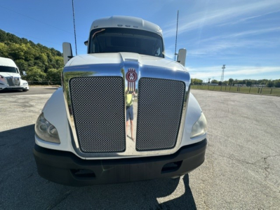 Kenworth T680 front view showing large chrome grille and KW emblem, headlights, and bumper.
